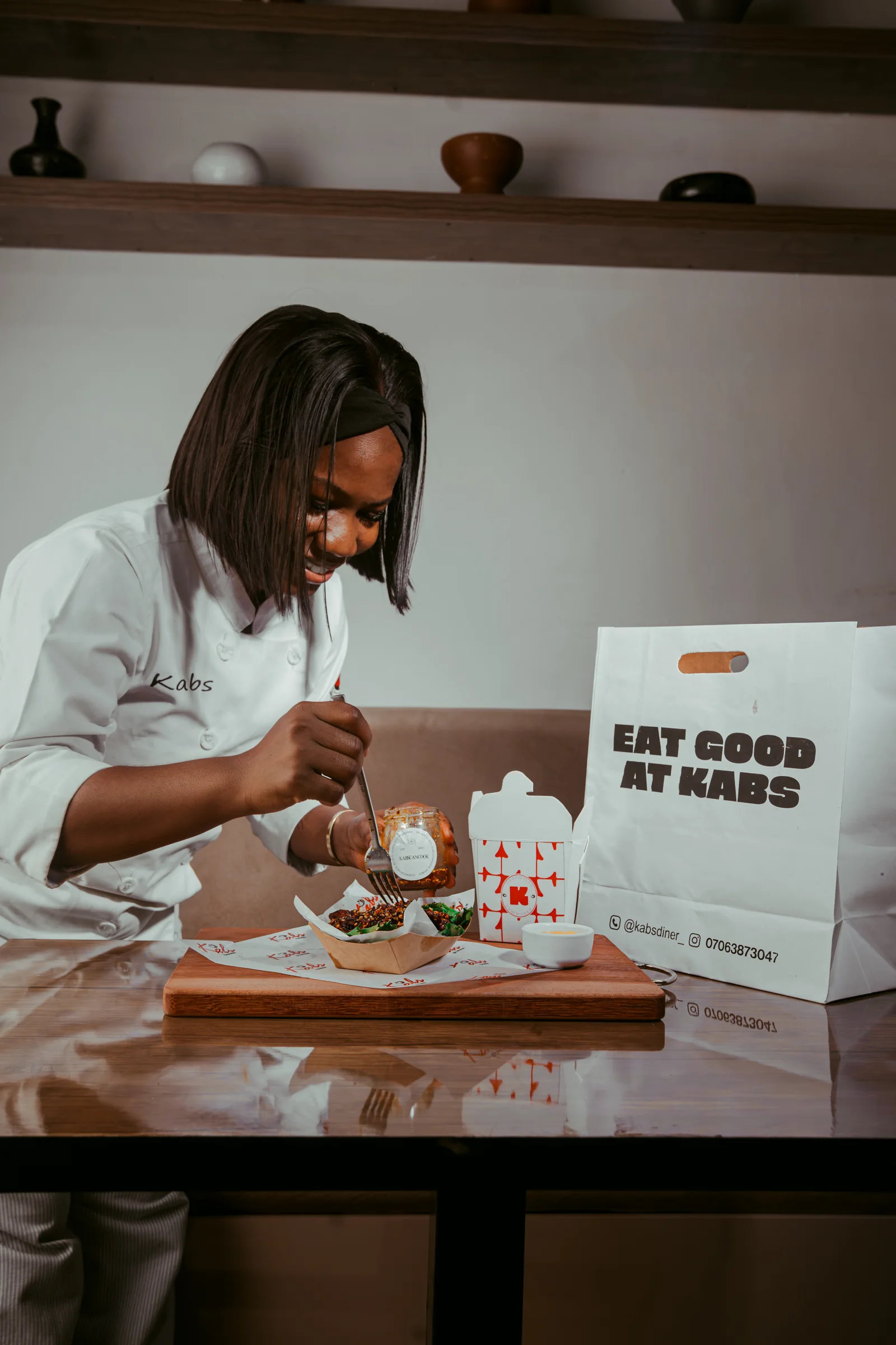 The head chef eating with a branded Eat Good At Kabs card