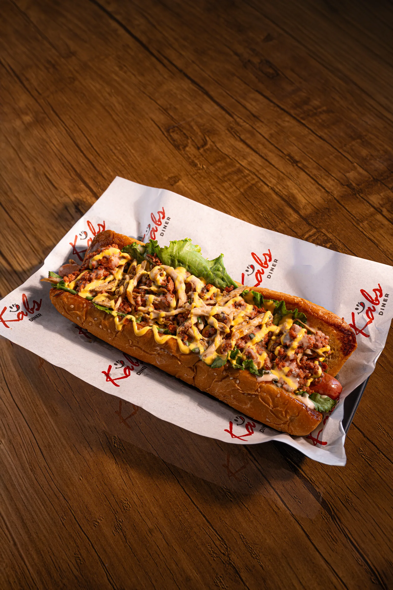 Pulled beef hotdog on branded paper