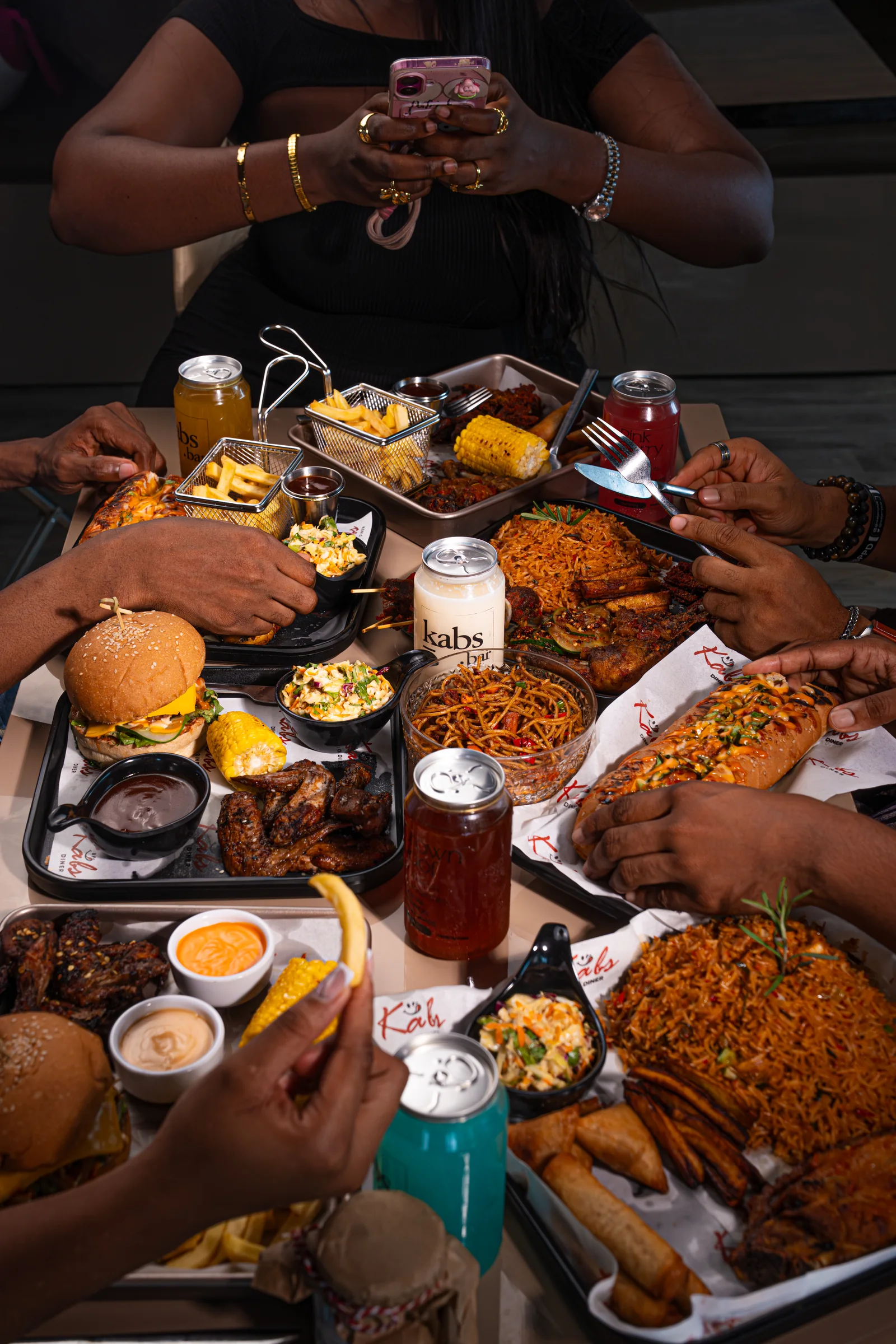 Sunday at Kabs, a shared table loaded with Kabs Diner food and branded drinks